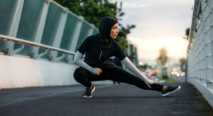 Image of a woman wearing sports clothes doing stretching workout outdoors