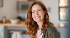 Image of a woman with long red hair, smiling, feeling at ease after depression therapy.
