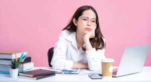 Young Asian women are tired from office work. Isolated Pastel Pink background