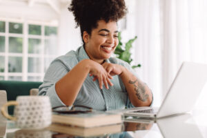 Smiling Black woman using laptop. Managing ADHD