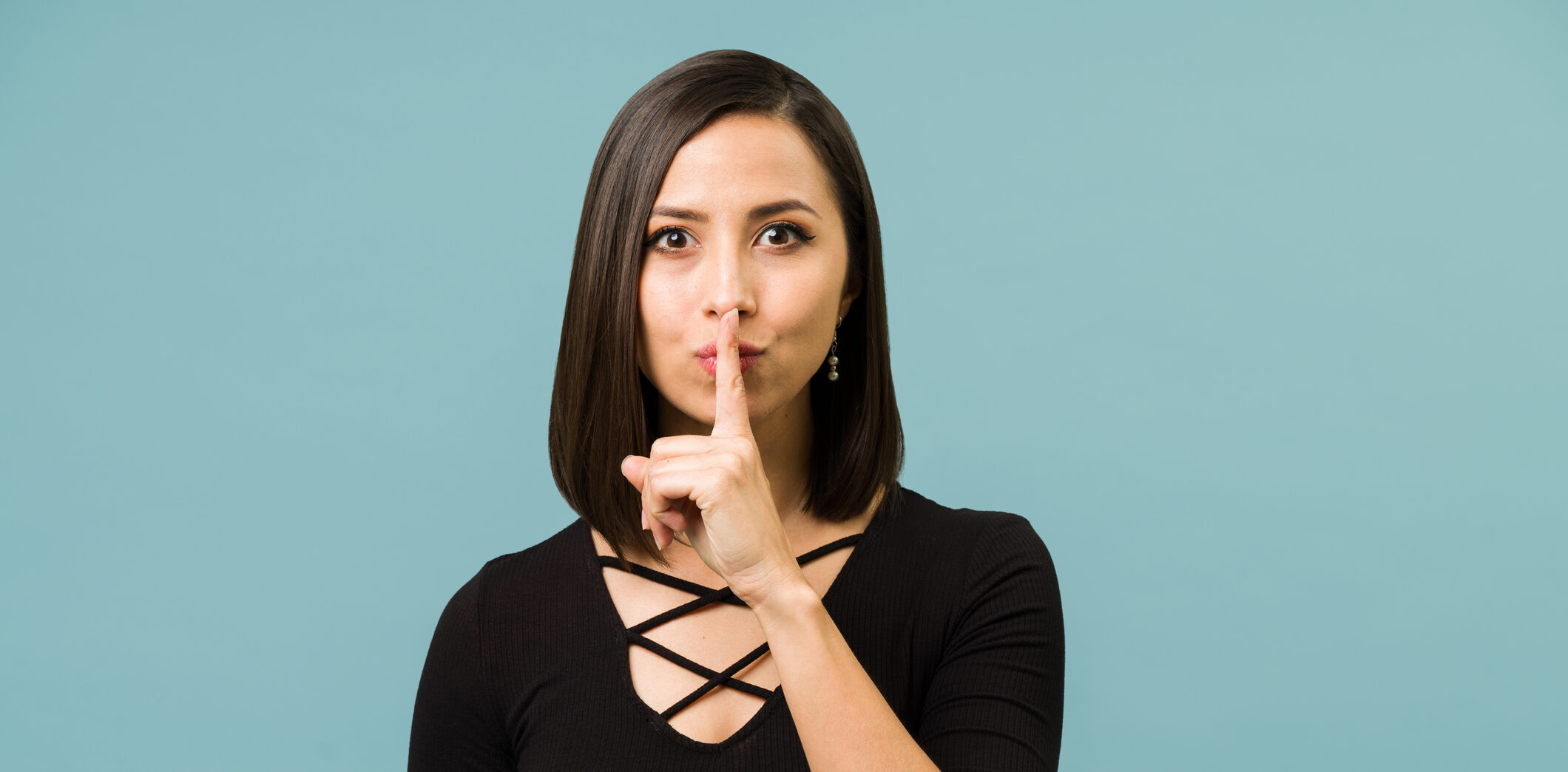 Woman indicating a family secret with her finger over her mouth