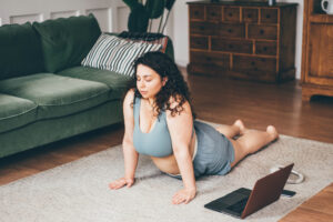 Plus size woman doing yoga and meditation at home.