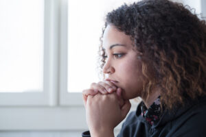 Image of a girl contemplating, looking lost in thought. 