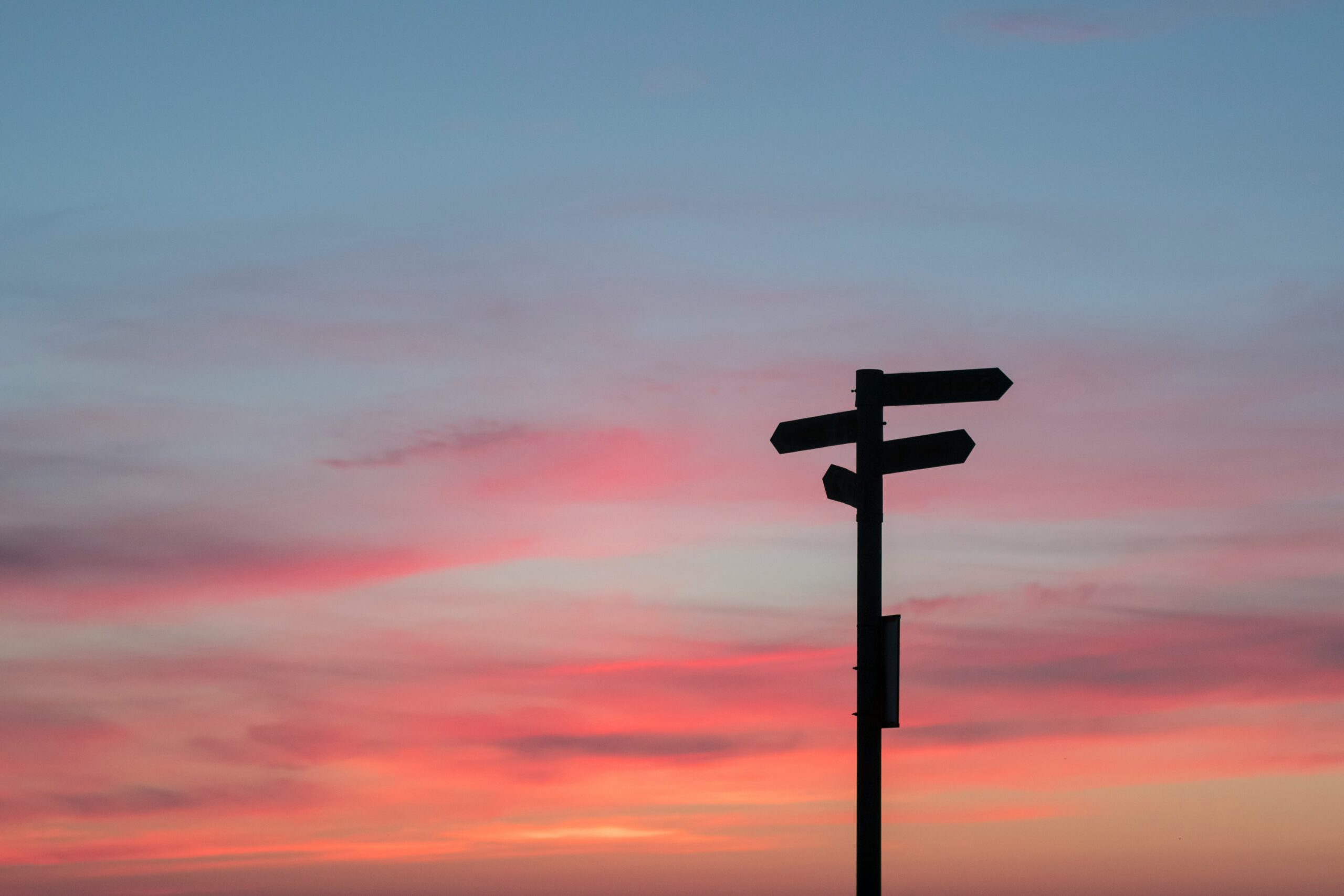 Sunset with directional signs symbolizing life transitions