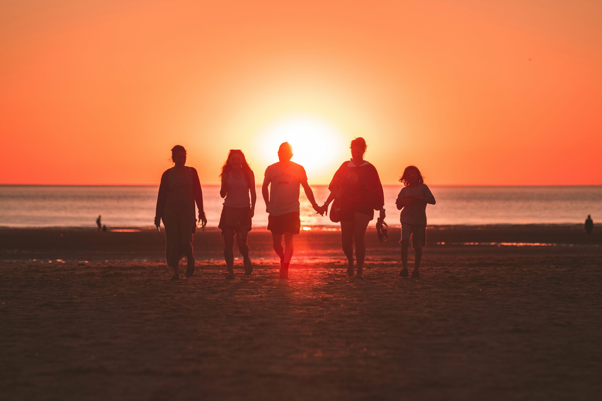 Silhouette of a family walking on a beach.