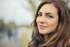 White presenting female with ADHD practicing self-care, smiling at camera