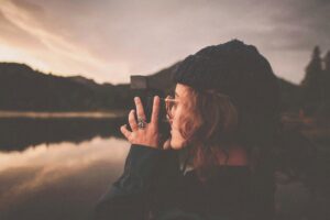 Female taking picture in the mountains with their camera after trauma therapy